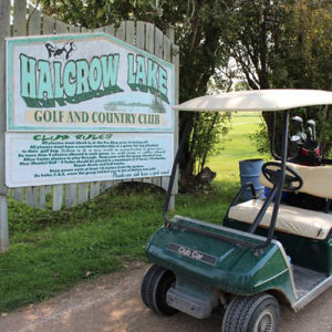 Golf cart in front of the main course sign