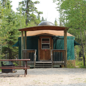 A yurt with covered deck, firepit and picnic table