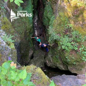 two kids looking up from within a crevace at the Caves