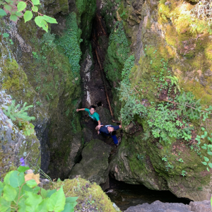 Two youth in a crevice looking up toward the camera
