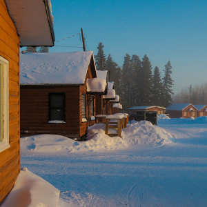 Rows of rental log cabins covered in snow